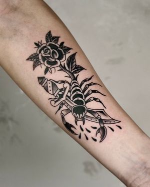 Traditional scorpion tattoo with a sword and rose