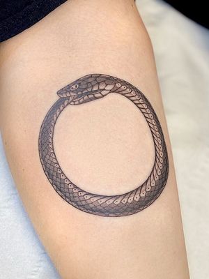 Classic black and gray snake tattoo on lower leg by artist Sophie Rose Hunter.