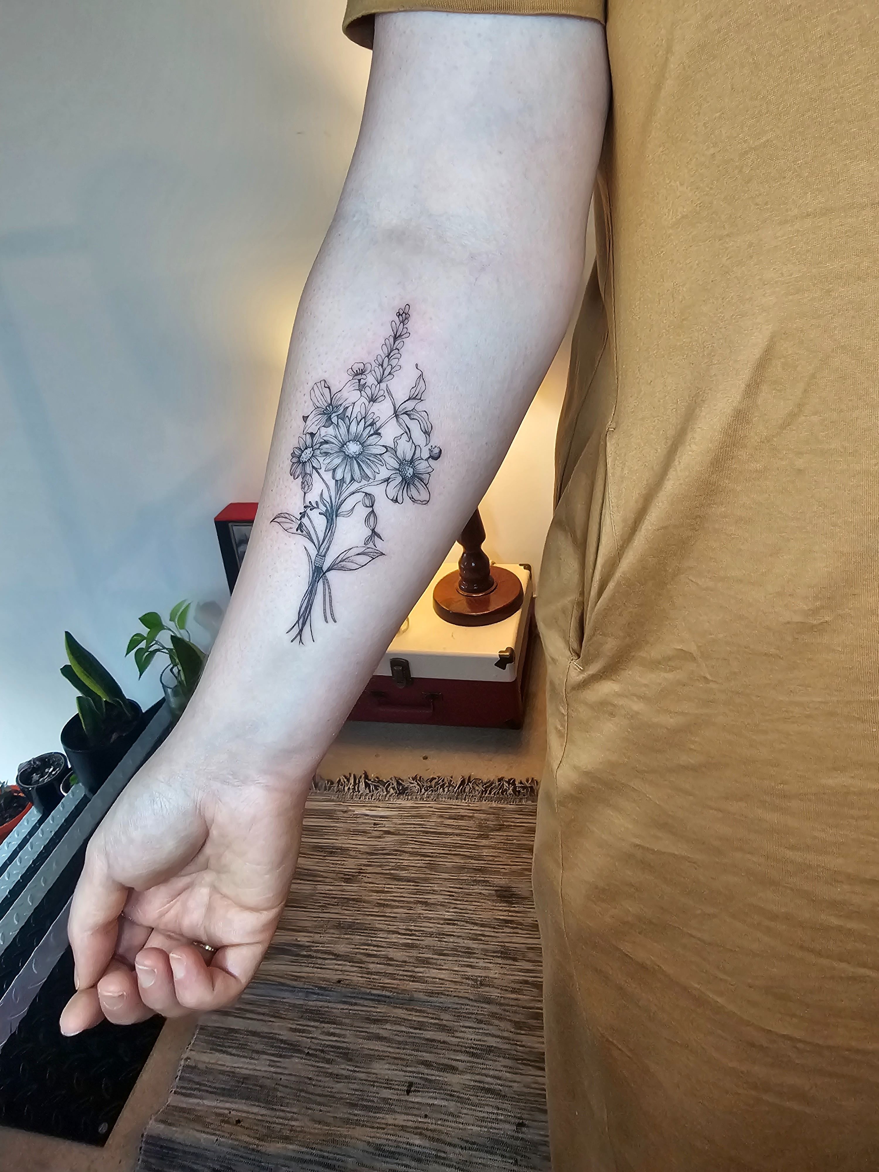 Flower bouquet tattoo located on the inner forearm.