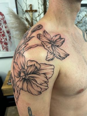 Beautiful floral design on upper arm by the talented artist Jack Howard. This tattoo features intricate flowers in a stunning style.