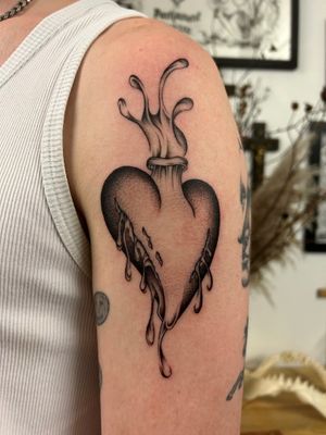 Elegant black and gray tattoo featuring a heart surrounded by delicate drops, expertly done by artist Jack Howard.