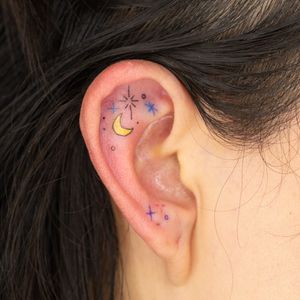 Get a cute and whimsical kawaii design on your ear with fine line art by Mika Tattoos. This delicate tattoo will add a touch of charm to your look.