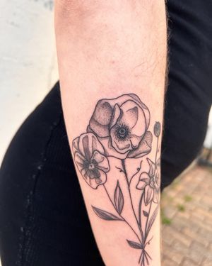 Exquisite fine line floral design on lower arm by Kiky Flore, blending elegance with intricate dotwork details.