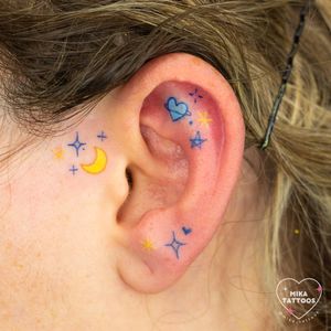 Adorn your ear with a delicate design of a moon, star, and heart by Mika Tattoos. Perfect for subtle elegance.