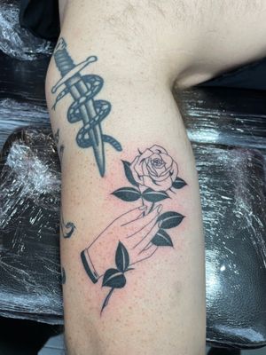 Get a beautiful illustrative tattoo of a rose on your hand by the talented artist Rich Sinner.