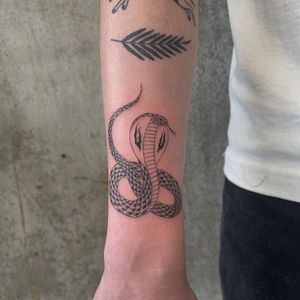 Experience the traditional charm of a cobra tattoo brought to life with illustrative style by artist Rich Sinner.