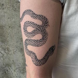 Experience the allure of tradition with this illustrative snake tattoo by renowned artist Rich Sinner.
