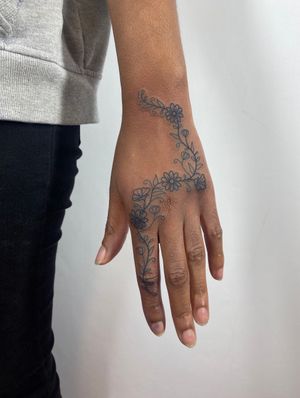Elegant hand tattoo featuring intricate floral design by Joanna Webb.