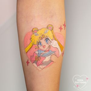 Get a colorful anime tattoo featuring Sailor Moon with a heart motif by Mika Tattoos. Perfect for anime lovers!