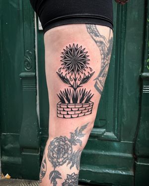 Adrimetric's illustrative blackwork tattoo features a striking flower motif, perfect for those looking for a unique and edgy design.