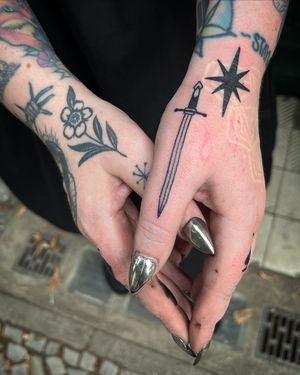 Adrimetric's striking blackwork design combines a mystical star with a bold sword illustration for a unique and powerful tattoo.