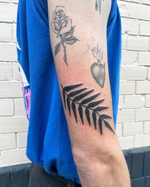 Adrimetric creates a stunning blackwork tattoo featuring a detailed vine and fern design.