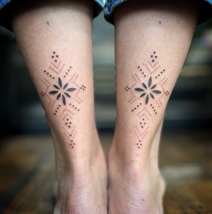 Elegant hand-poked design on lower leg by Indigo Forever Tattoos, featuring intricate ornamental dotwork pattern.