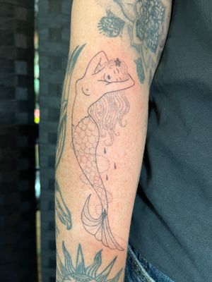 Elegant and intricate lower arm tattoo featuring a beautiful mermaid design in dotwork and fine line style by Indigo Forever Tattoos.