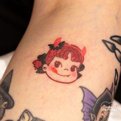 Get a cute yet devilish kawaii design featuring Peko Chan and crayon elements from Mika Tattoos for a fun Halloween-inspired look!