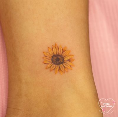 Experience the sublime beauty of this realism watercolor sunflower tattoo by renowned artist Mika Tattoos. Vibrant colors and stunning detail combine for a truly unique piece of body art.