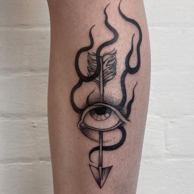 A striking blackwork tattoo by Jenny Dubet on the shin, featuring a mesmerizing blend of arrows and eyes in dotwork and fine line style.