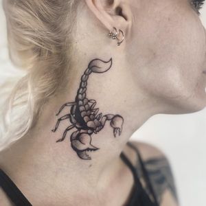 Bold traditional scorpion tattoo on the neck by artist Jenny Dubet. A striking design that showcases strength and protection.