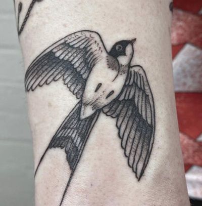 A classic traditional swallow tattoo by artist Jenny Dubet, elegantly inked on the forearm.