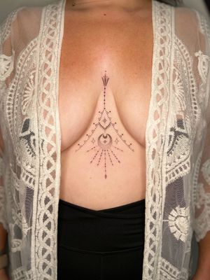 Elegant dotwork and fine line tattoo featuring a sun and moon design on the sternum, by Viví Bogdanov.