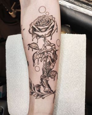 Great black and grey rose being held by skeleton hand. 