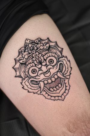 Experience Bali's mystical essence with this striking Japanese illustrative tattoo of a Barong mask by artist Alejandro.