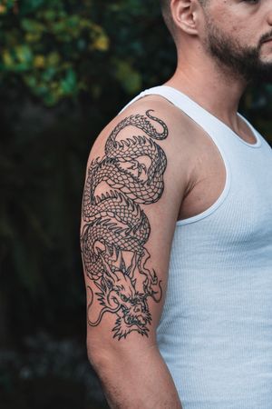 Immerse yourself in the mythical world with this detailed Japanese dragon tattoo by the talented artist ALEJANDRO.