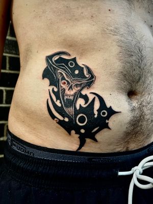 Experience the horror with this blackwork neo tribal tattoo of a reaper on your stomach, expertly done by Misa.