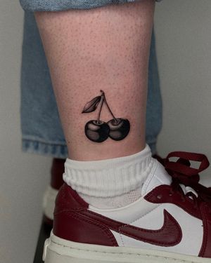 Get a sweet touch with this black and gray cherry tattoo. Perfect for your ankle. Done by the talented artist Ophelya Jeandat.