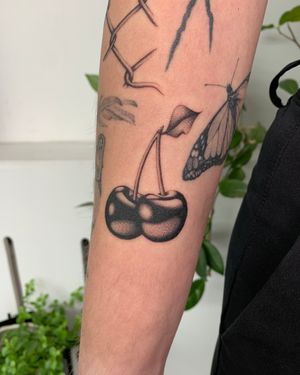 Capture the beauty of cherries in stunning black and gray on your arm with this unique tattoo designed by Ophelya Jeandat.