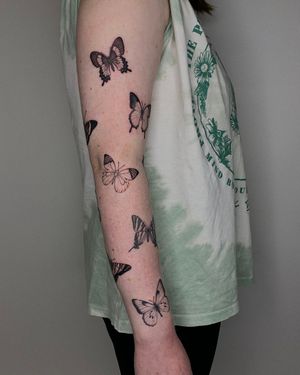 Elegant black and gray butterfly tattoo on arm, by the talented artist Ophelya Jeandat.