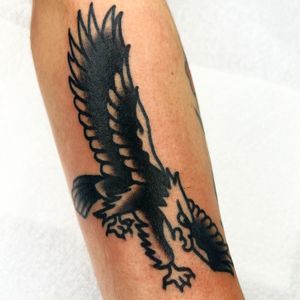 Get a striking traditional eagle tattoo by renowned artist Alessandro Lanzafame. Symbolizing strength and freedom, this design is perfect for bold individuals.