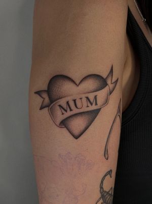 Classic traditional tattoo featuring a heart and name on the arm by Ophelya Jeandat.