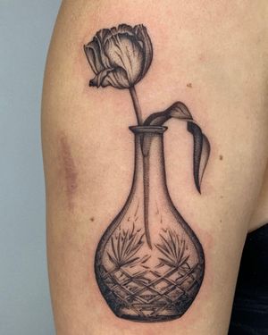 Beautiful black and gray dotwork tattoo of a delicate peony in a vase by Ophelya Jeandat.