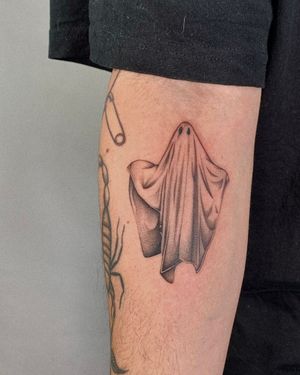 A hauntingly beautiful dotwork and illustrative tattoo of a ghost draped in a sheet, expertly done by Ophelya Jeandat.