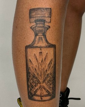 Get a stunning black and gray realism tattoo of a vintage glass bottle by Ophelya Jeandat. Perfect for those who appreciate classic designs.