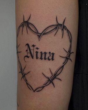 Unique dotwork design featuring a heart with barbed wire and thorns, personalized with the name 'Nina' by artist Ophelya Jeandat.