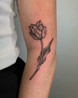 Beautiful floral design by Ophelya Jeandat, featuring a delicate tulip motif. Perfect for a classy and feminine arm tattoo.