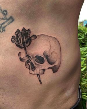 Unique dotwork and fine line tattoo combining floral and skull motifs by Ophelya Jeandat.