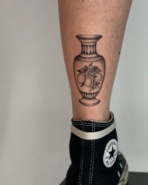 Stunning black and gray illustrative tattoo featuring a Greek vase adorned with lemons, by the talented artist Ophelya Jeandat.