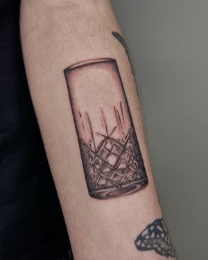 Experience the stunning realism of a crystal or glass tattoo on your arm in black and gray. Perfect for those who appreciate the beauty of nature's elements.