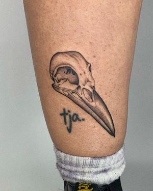 Illustrative black and gray tattoo featuring a majestic crow and a haunting skull, beautifully done by Ophelya Jeandat.