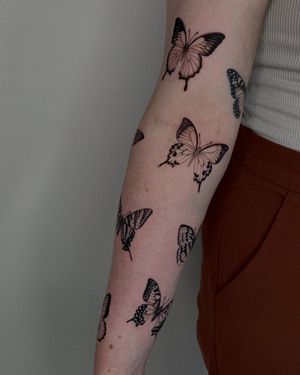 Elegant butterfly design by Ophelya Jeandat, beautifully inked on the arm in stunning black and gray style.
