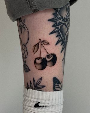 Get a timeless black and gray cherries tattoo on your lower leg by the talented Ophelya Jeandat.