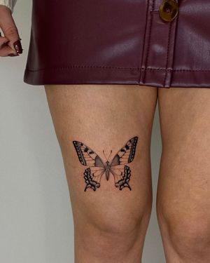 Elegant and delicate butterfly design on the upper leg, created with fine line technique by talented artist Ophelya Jeandat.