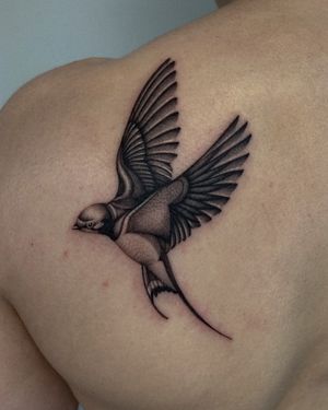 Get a stunning black and gray dotwork swallow tattoo by the talented artist Ophelya Jeandat. An intricate and timeless design.
