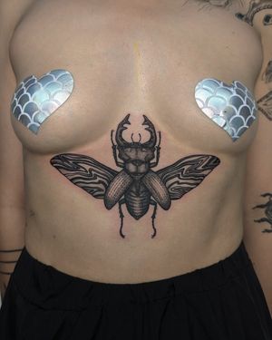 Explore the beauty of blackwork, dotwork, and hand-poked techniques in this illustrative beetle tattoo by Alien Ink.