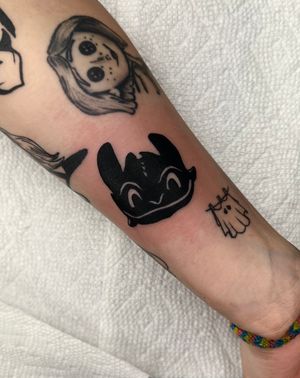 Get your own fierce Toothless tattoo inspired by How to Train Your Dragon, expertly done in bold blackwork style by tattoo artist Miss Vampira.