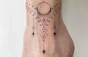 Capture the magic of the moon and stars with this intricate hand-poked dotwork tattoo by Indigo Forever Tattoos.