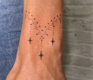 Indigo Forever Tattoos creates a mesmerizing star motif using hand-poked dotwork technique on your forearm.